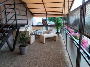 a balcony with a couch and a table and plants at Penzión CONTESA in Rožňava