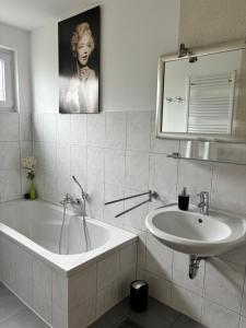 bagno con vasca, lavandino e specchio di Altes Zollhaus a Fehmarn Altre 27 foto