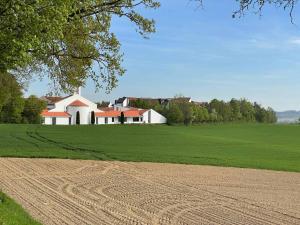 a large field with a house in the background at Appartement am Brunnenplatzl mit Bademantelzugang in Bad Griesbach
