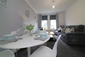 a living room with a white table and chairs at Signature - Gartlea House in Airdrie