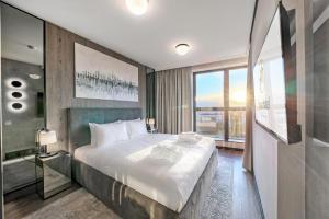 a bedroom with a large bed and a large window at Focus Hotel Premium Warszawa in Warsaw