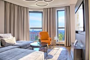 a living room with a couch and a chair at Focus Hotel Premium Warszawa in Warsaw
