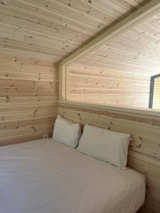 una camera da letto con letto in una camera in legno di Camping Santa Elena a Lloret de Mar