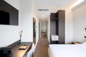 Schlafzimmer mit einem Bett und einem Schreibtisch mit einem TV in der Unterkunft Hotel Carlton in Treviso