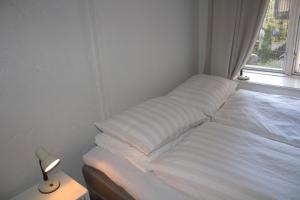 a white bed in a room with a window at Nordic Host - Deichmans Gate 10 in Oslo