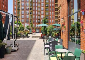 an outdoor patio with tables and chairs and buildings at Superb 1 bedroom in the best zone of the city. in Ferizaj