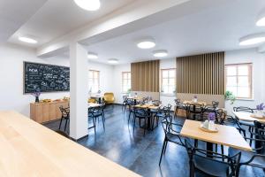 a dining room with tables and chairs and a chalkboard at Penzion Nad Pavlovem in Pavlov
