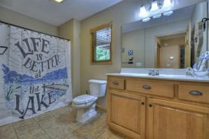 a bathroom with a toilet and a sink and a mirror at Anchors Away - Lake Nottely - Blairsville GA - Hot Tub, Private Dock, Fire Pits, and Stunning Lake Views at Lake Nottely in Mashburn Mill +25 photos