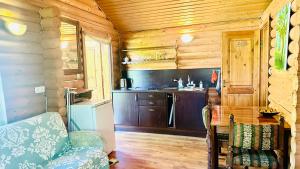 a kitchen in a log cabin with a couch at Audrones sodyba in Šventoji