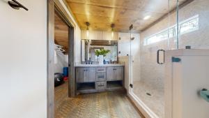 ein Badezimmer mit Dusche, Waschbecken und Spiegel in der Unterkunft Blue Run Cabin - Luxury Retreat Blue Ridge Heights - Hot Tub, Movie Theater, Game Room, Fire Pit, Mountain Views - Blue Ridge, G in Blue Ridge + 64 Fotos