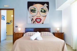a bedroom with a bed with a painting of a woman at Ostello Bortone in Castelnuovo Cilento