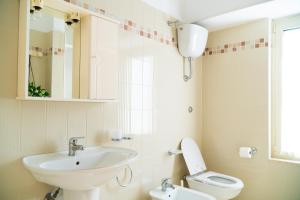 a bathroom with a sink and a toilet and a mirror at Ostello Bortone in Castelnuovo Cilento