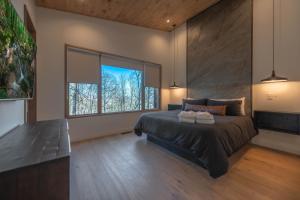 Un dormitorio con una cama grande y una ventana grande. en Capstone - Modern Luxury Cabin Full Mountain View, en Blue Ridge