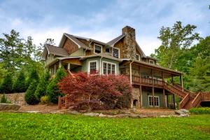 a large house with a porch on a green lawn at Blue Ridge Lake Retreat - Lakefront Luxury Home - Private Dock, Hot Tub, Sundeck, Private Boat Launch, Near Downtown - Blue Ridg in Blue Ridge