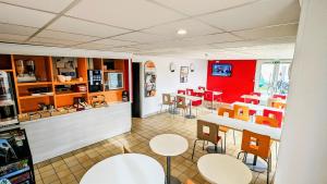 a room with tables and chairs in a restaurant at PREMIERE CLASSE ANGERS SUD Louvre Hotels group in Les Ponts-de-Cé