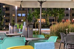 an outdoor patio with tables and chairs and a building at Focus Hotel Premium Warszawa in Warsaw