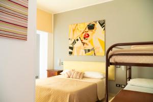 a bedroom with a bed and a painting on the wall at Ostello Bortone in Castelnuovo Cilento