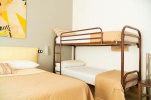 a room with two bunk beds and a table at Ostello Bortone in Castelnuovo Cilento