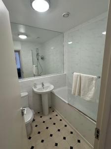 a white bathroom with a sink and a toilet at Super Central Cambridge Flat For Up To 4 People in Cambridge