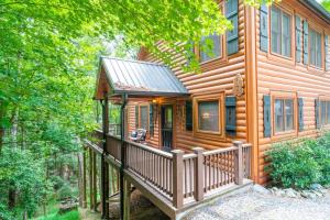 a log cabin with a porch and a deck at Hibernation Station - Hot Tub, Fireplace, Serene Forest Views - Cherry Log, GA in Blue Ridge