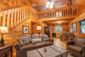 a living room with a couch and a table at Hibernation Station - Hot Tub, Fireplace, Serene Forest Views - Cherry Log, GA in Blue Ridge