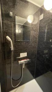 a bathroom with a shower with a mirror at Sound Garden Biei, Cricket in Biei +13 photos