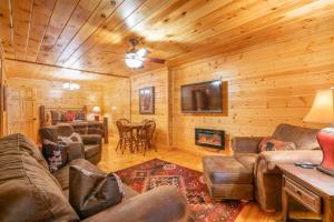 a living room with couches and a fireplace in a log cabin at Hibernation Station - Hot Tub, Fireplace, Serene Forest Views - Cherry Log, GA in Blue Ridge