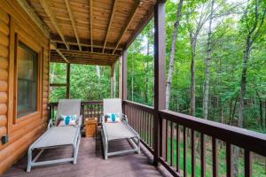 two chairs on the porch of a cabin at Hibernation Station - Hot Tub, Fireplace, Serene Forest Views - Cherry Log, GA in Blue Ridge