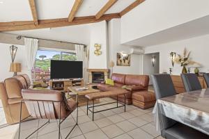 un soggiorno con un divano e una TV di Villa à 200m de la plage a Sainte-Maxime