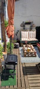 a patio with a couch and a table on a deck at Villa Seven Malo in Dunkerque
