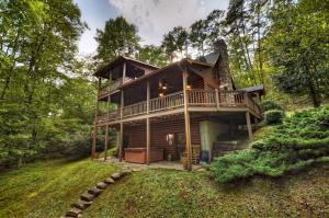 a cabin in the woods with a wrap around deck at Hogback Haven - Arcade Games, Hot Tub, Fire Pit, Cozy Amenities, Rocking Bench, Private Wooded View - Blue Ridge, GA in Blue Ridge