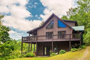 a house on a hill with a wrap around deck at Hawks Hideaway in Mineral Bluff