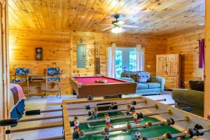 a log cabin living room with a pool table at Hawks Hideaway in Mineral Bluff