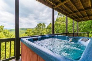a hot tub on the balcony of a house at Hawks Hideaway in Mineral Bluff