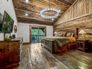 ein Schlafzimmer mit einem Bett und einer Holzwand in der Unterkunft Misty Trail Lakehouse - Lake Blue Ridge Luxury Home - Private Dock Firepit in Morganton + 65 Fotos