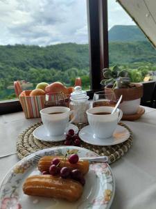 a table with plates of food and cups of coffee at Holiday Home Casa Rondo in Bihać
