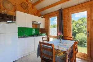a kitchen and dining room with a table and chairs at Chalet Pondok Indah in Plouégat-Moysan