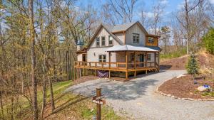 a house in the woods with a sign in front of it at Rustic Elegance - Cabin Near Toccoa River in Blue Ridge