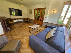a living room with a blue couch and a table at Villa Bajocasse, maison Bayeux Centre Historique - 4 chambres in Bayeux