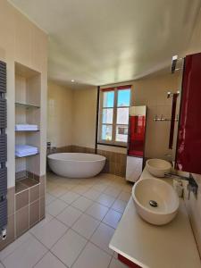 a large bathroom with a tub and a sink and a toilet at Villa Bajocasse, maison Bayeux Centre Historique - 4 chambres in Bayeux +25 photos