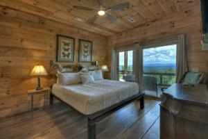 a bedroom with a bed and a large window at Skys The Limit - Blue Ridge Cabin - Pet Friendly in Mineral Bluff