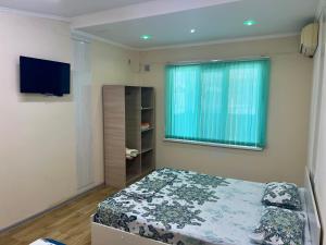 a small bedroom with a bed and a window at Гостевой дом Сафар in Kapchagay