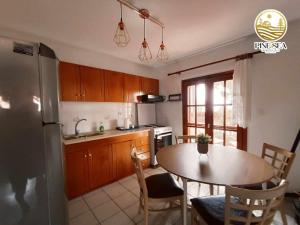 a kitchen with a table and a kitchen with a refrigerator at Pine & sea house in Nikiti