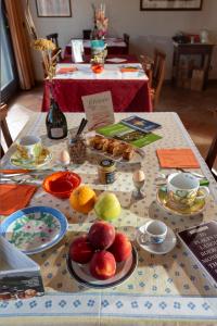 a table with plates of fruit and cups on it at Cascina Giardini in Alba