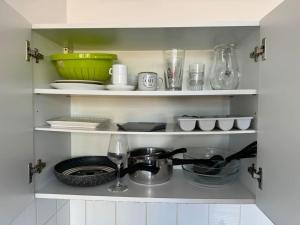 a kitchen shelf with bowls and dishes and a sink at Joli studio au coeur de Valence 41 in Valence