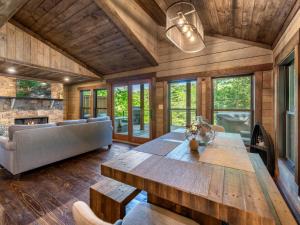 a living room with a wooden table and a couch at A Little Stoney River - Ellijay GA - Cartecay River in Ellijay