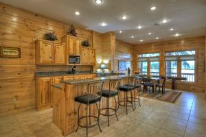 a kitchen with wooden cabinets and a bar with stools at When in Rome - Luxury Lakeside Blue Ridge Cabin - Spacious Lakeside Luxury, Hot Tub, Game Room, Lake Dock, Steps To Lake Blue Ri in Blue Ridge