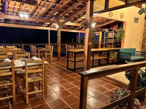 an empty restaurant with wooden tables and chairs at Pousada Tribo Do Sol in Ubatuba
