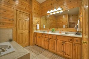 a bathroom with two sinks and a large mirror at When in Rome - Luxury Lakeside Blue Ridge Cabin - Spacious Lakeside Luxury, Hot Tub, Game Room, Lake Dock, Steps To Lake Blue Ri in Blue Ridge +50 photos