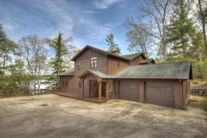a large wooden house with a garage at When in Rome - Luxury Lakeside Blue Ridge Cabin - Spacious Lakeside Luxury, Hot Tub, Game Room, Lake Dock, Steps To Lake Blue Ri in Blue Ridge